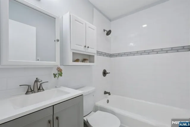 a bathroom with a sink toilet vanity and tub
