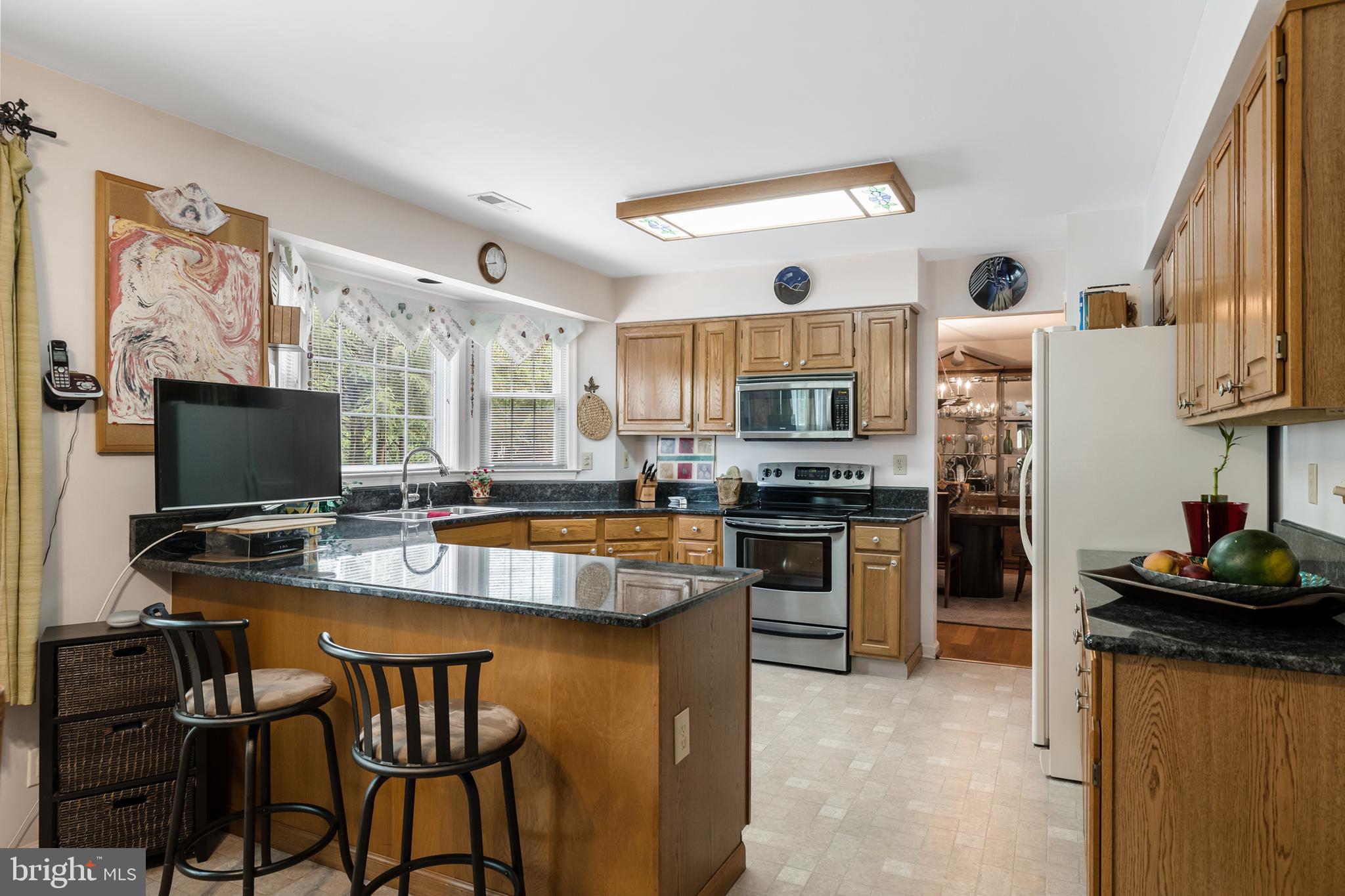 10 Tansgate Boulevard Berlin, NJ 08009 - Photo 16 of 51 a kitchen with stainless steel appliances granite countertop a stove top oven a sink dishwasher and a refrigerator with wooden floor