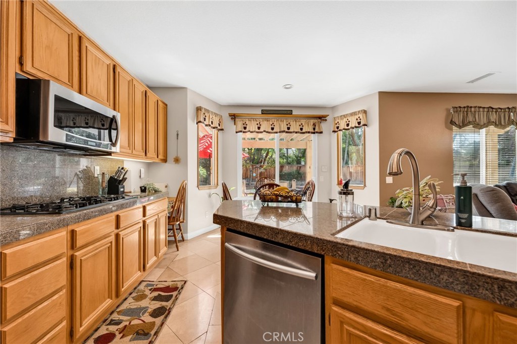 6874 Raspberry Court Eastvale, CA 92880 - Photo 12 of 36 a kitchen with stainless steel appliances a sink stove and cabinets