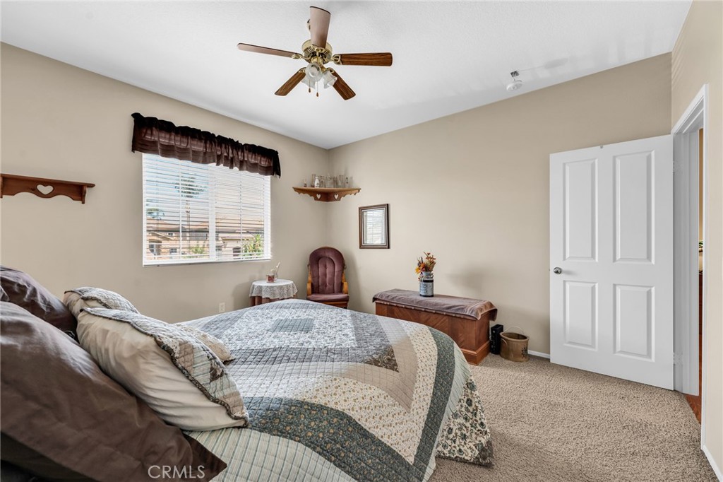 6874 Raspberry Court Eastvale, CA 92880 - Photo 17 of 36 a bedroom with a large bed and a window