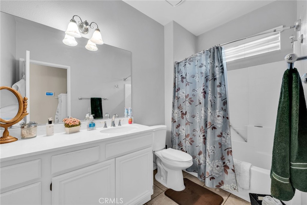 6874 Raspberry Court Eastvale, CA 92880 - Photo 19 of 36 a bathroom with a sink a toilet and a mirror