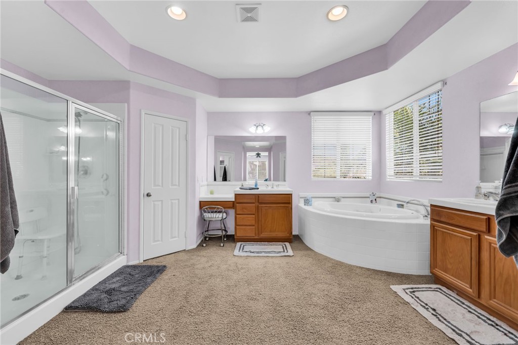 6874 Raspberry Court Eastvale, CA 92880 - Photo 24 of 36 a spacious bathroom with a tub sink shower and mirror