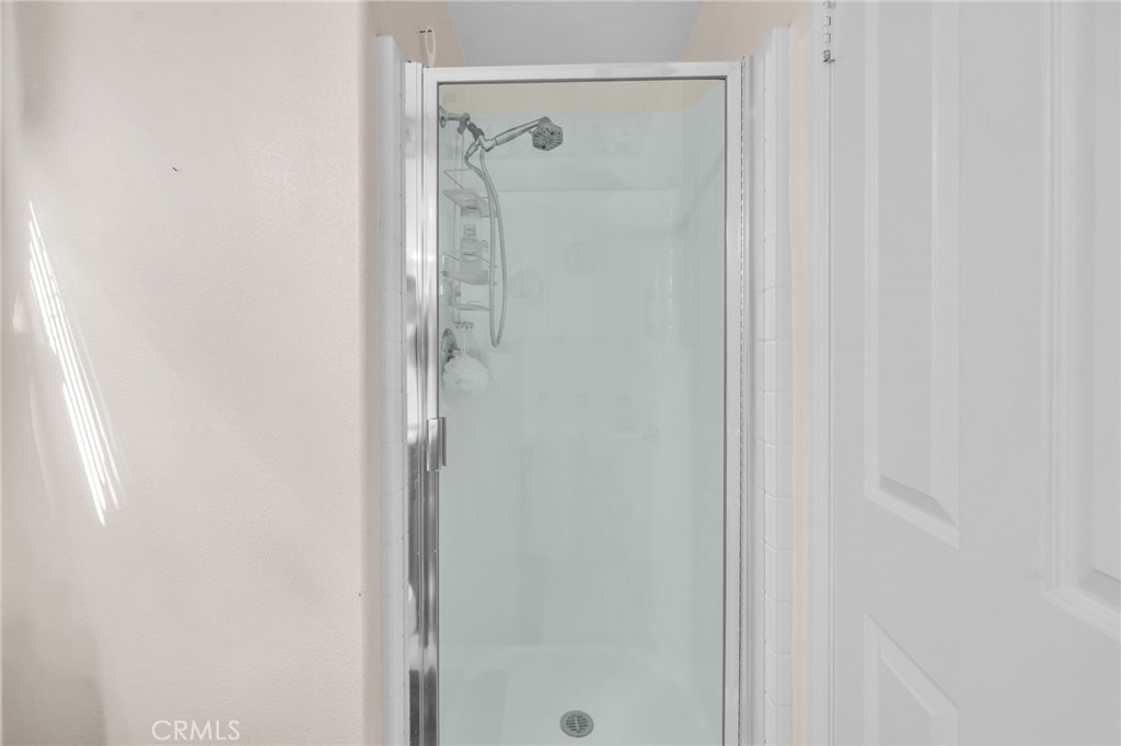 6874 Raspberry Court Eastvale, CA 92880 - Photo 28 of 36 a bathroom with a glass shower door