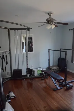 a room with gym equipment and wooden floor