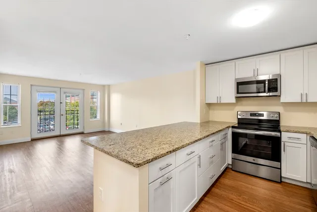 a kitchen with stainless steel appliances granite countertop a stove a sink and a microwave