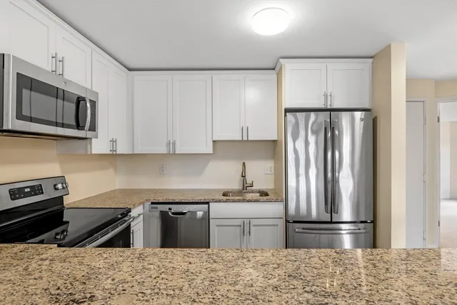 a kitchen with stainless steel appliances granite countertop a refrigerator stove and sink