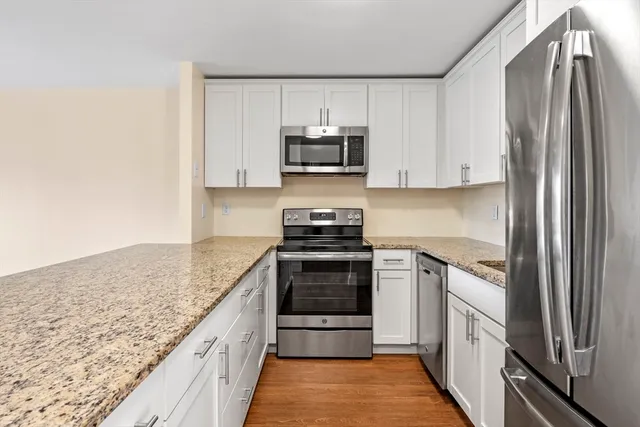 a kitchen with stainless steel appliances granite countertop a stove and a refrigerator