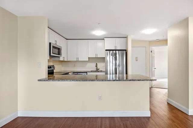 a view of empty room with wooden floor