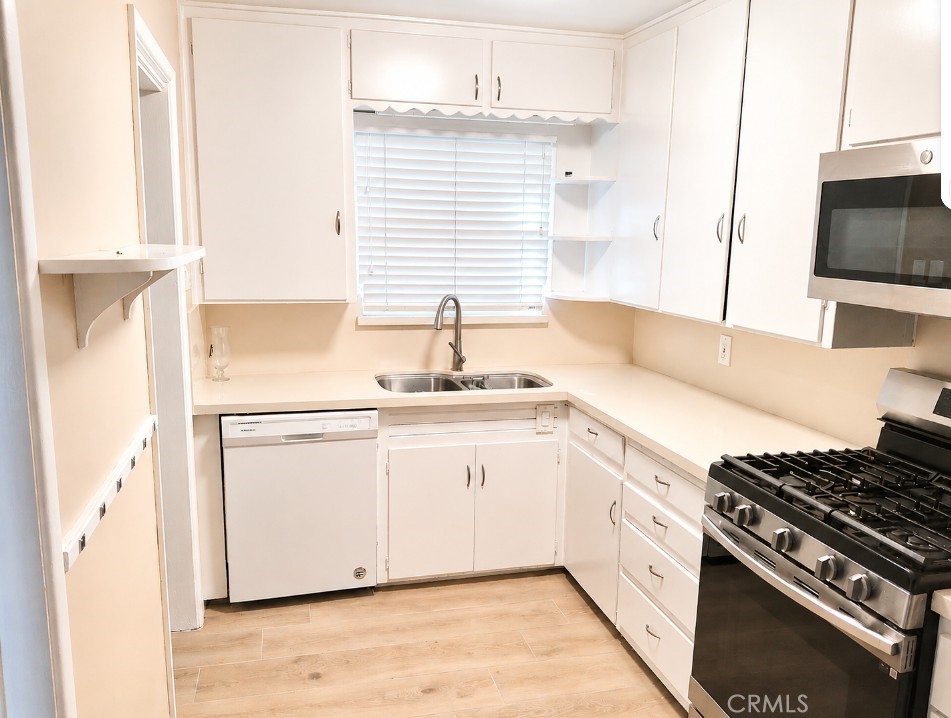 6735 Yellowstone Drive, Unit A Riverside, CA 92506 - Photo 10 of 14 a kitchen with stainless steel appliances white cabinets and wooden floor
