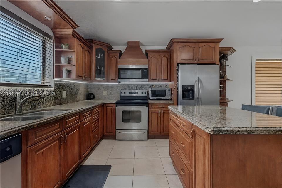 10351 Southwest 49th Street, Unit MAIN Miami, FL 33165 - Photo 6 of 21 a kitchen with stainless steel appliances granite countertop a stove sink and cabinets