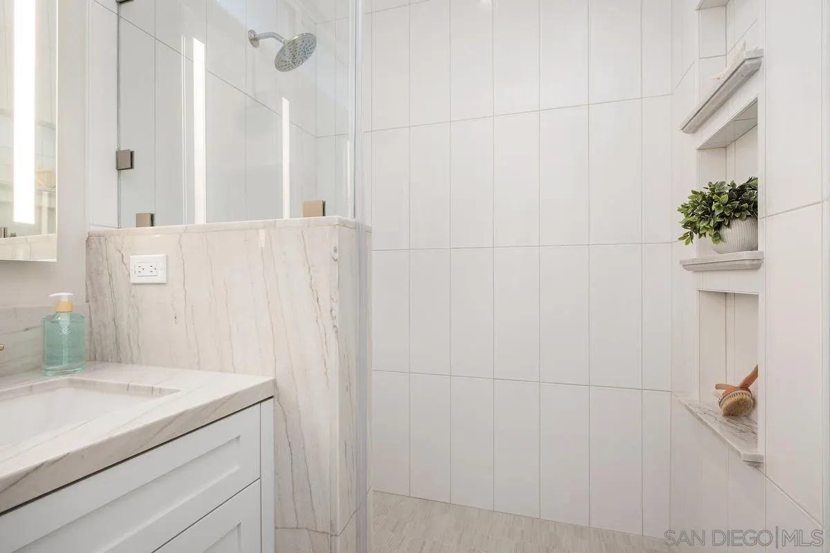 559 North Vulcan Avenue Encinitas, CA 92024 - Photo 26 of 50 a bathroom with a granite countertop sink a mirror and a shower