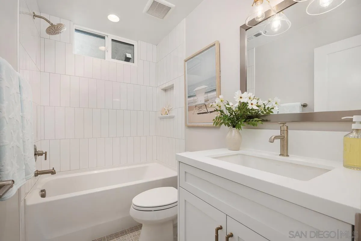 559 North Vulcan Avenue Encinitas, CA 92024 - Photo 30 of 50 a bathroom with a sink a toilet a mirror a vanity a bathtub and shower