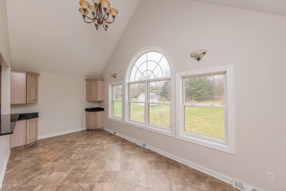 6947 Som Center Road Solon, OH 44139 - Photo 36 of 50 Unfurnished living room with a notable chandelier, light tile floors, and high vaulted ceiling
