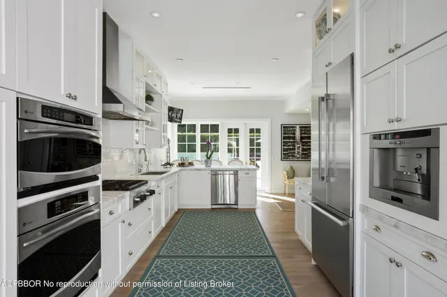 a kitchen with stainless steel appliances kitchen island granite countertop a stove a sink and a refrigerator