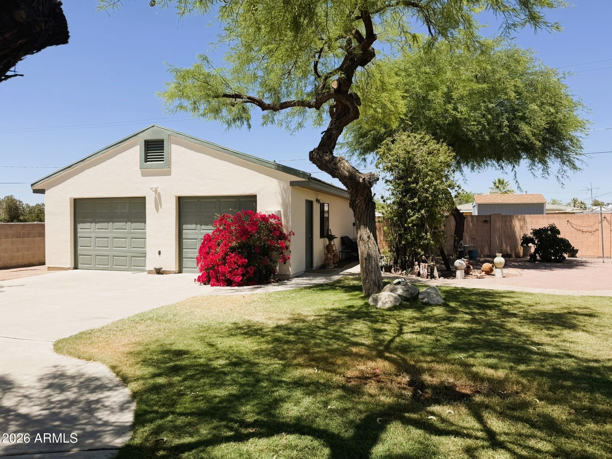 6334 East Albany Street Mesa, AZ 85205 - Photo 48 of 72 a front view of a house with a garden and trees