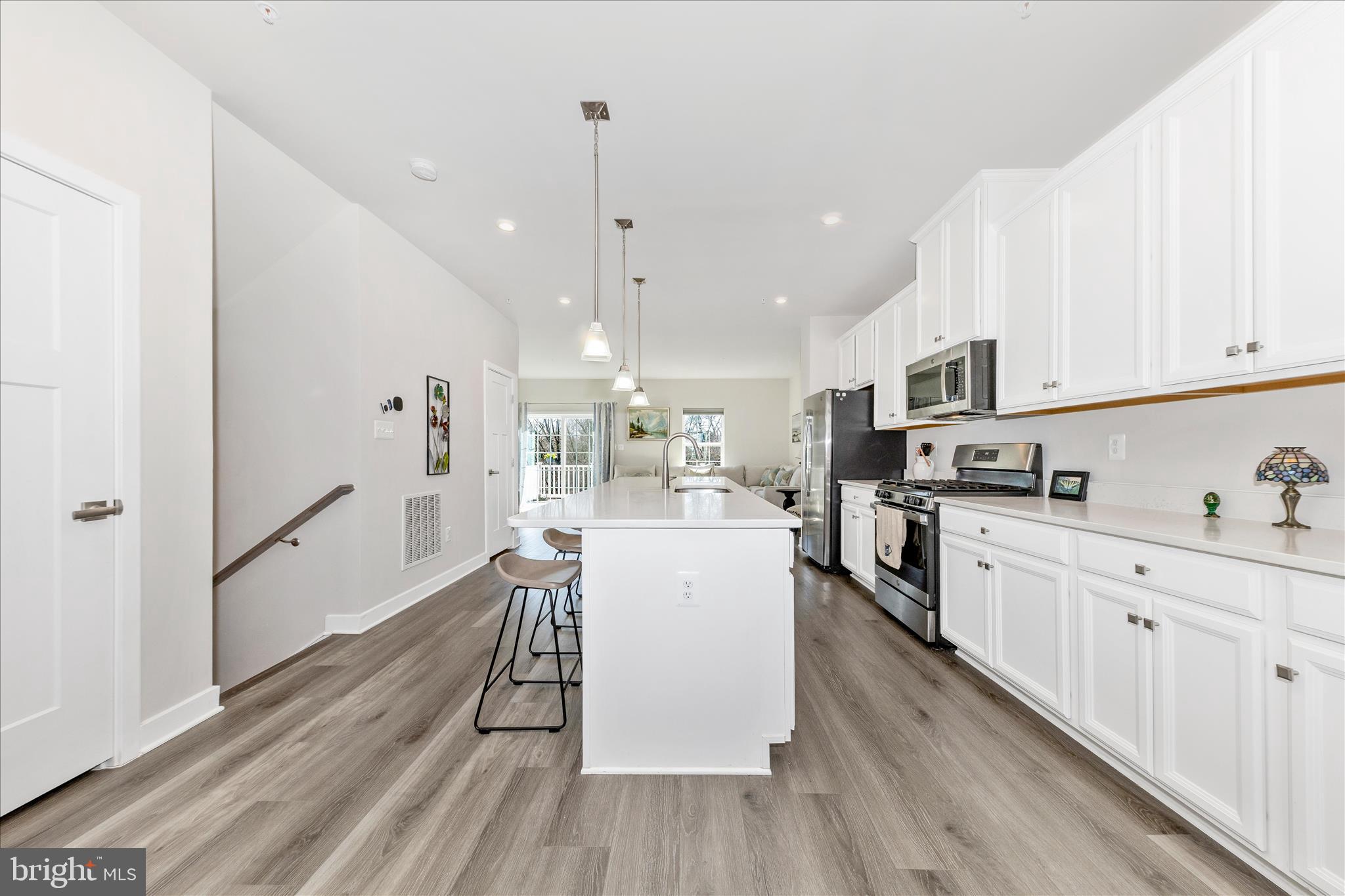1736 Atlas Drive Frederick, MD 21702 - Photo 17 of 99 a kitchen with stainless steel appliances kitchen island granite countertop a stove a sink a refrigerator and white cabinets with wooden floor