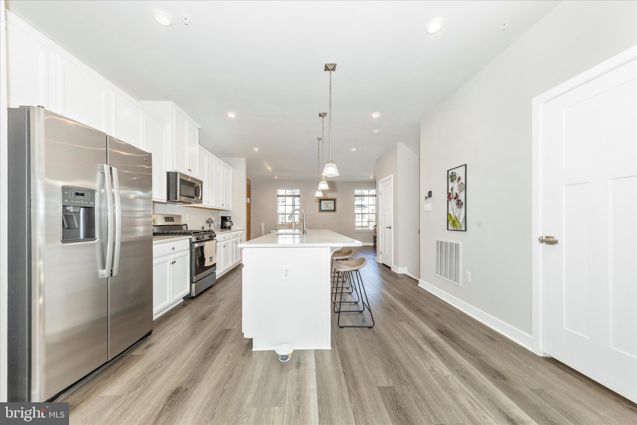 1736 Atlas Drive Frederick, MD 21702 - Photo 62 of 99 a kitchen with stainless steel appliances a refrigerator a stove top oven a sink dishwasher and white cabinets with wooden floor