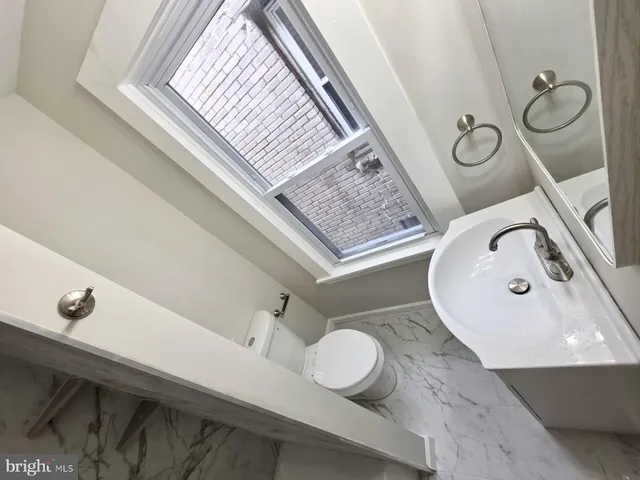 a bathroom with a toilet sink and mirror