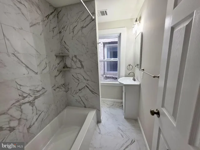 a bathroom with a bathtub and shower