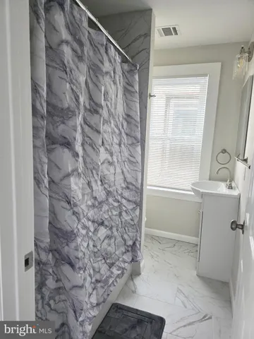 a bathroom with a shower and a sink