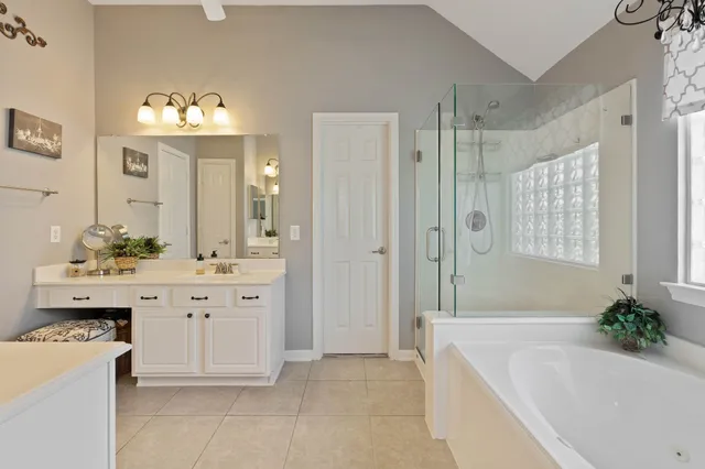 a spacious bathroom with a tub sink and mirror