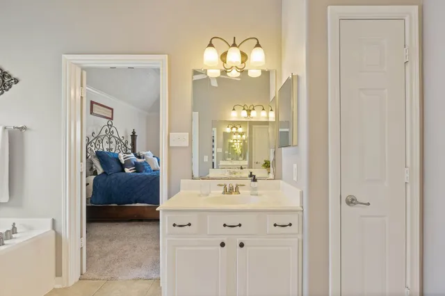 a en suite bathroom with a sink mirror and a bathtub