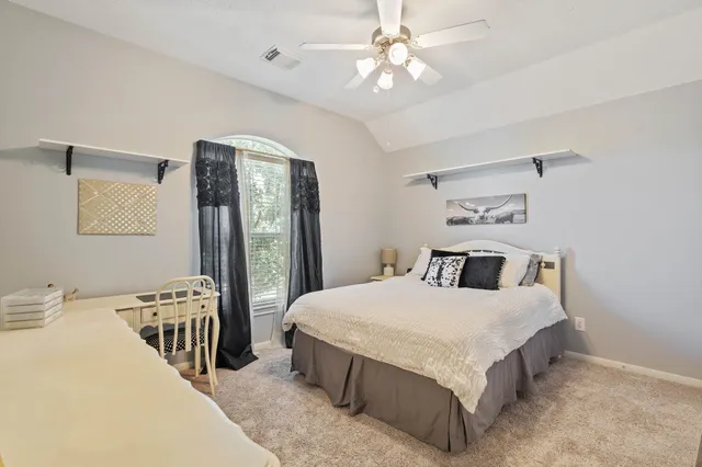 a bedroom with a bed a chandelier and dresser