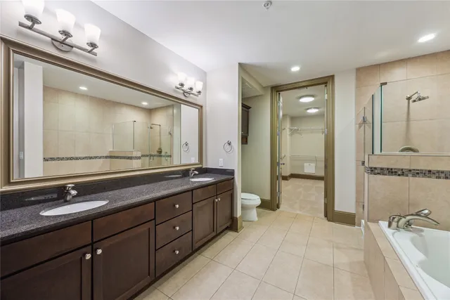 a bathroom with a double vanity sink a large mirror and a shower