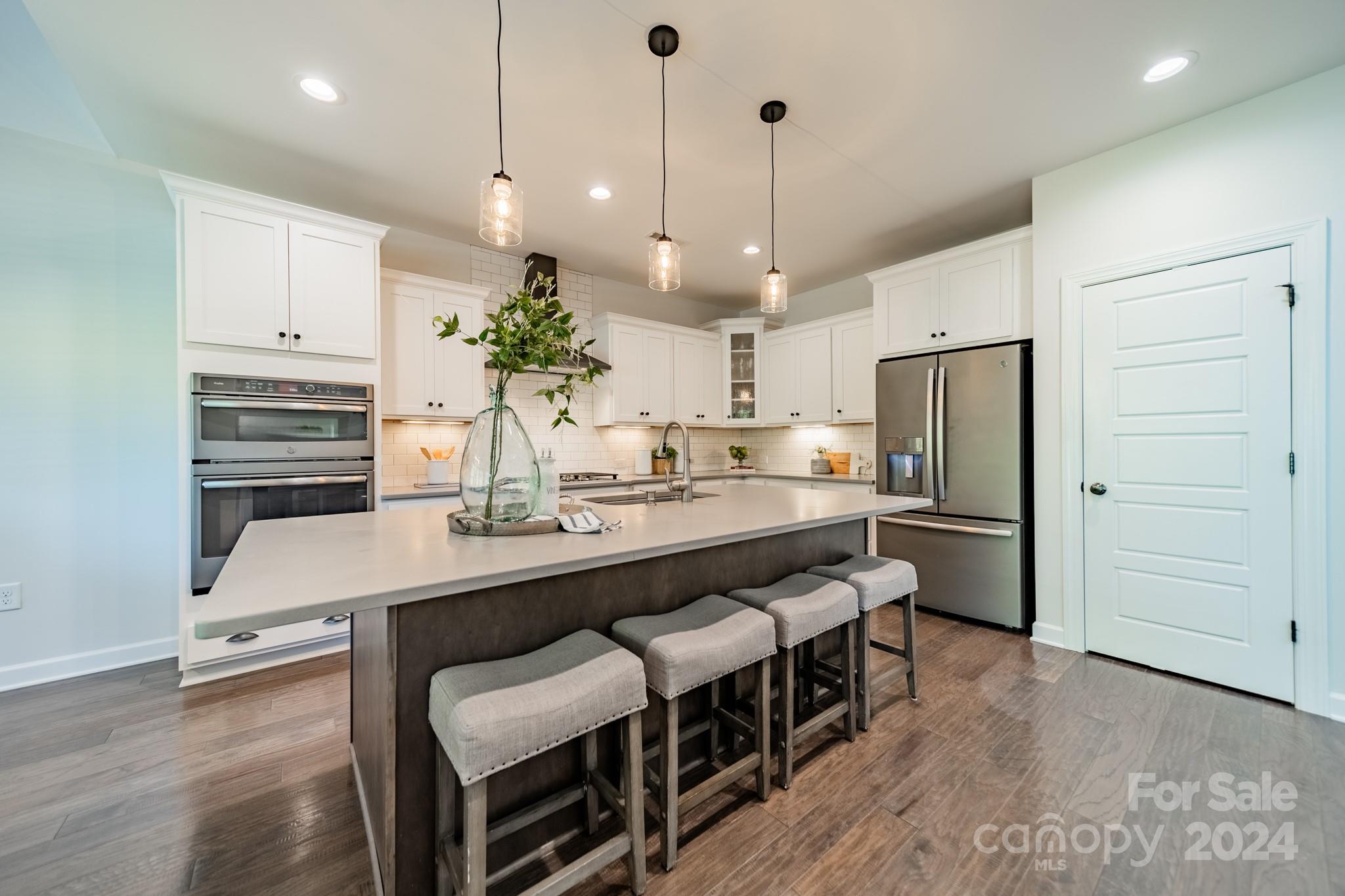 2826 Walker Road Matthews, NC 28105 - Photo 21 of 45 a kitchen with stainless steel appliances a table chairs refrigerator and cabinets