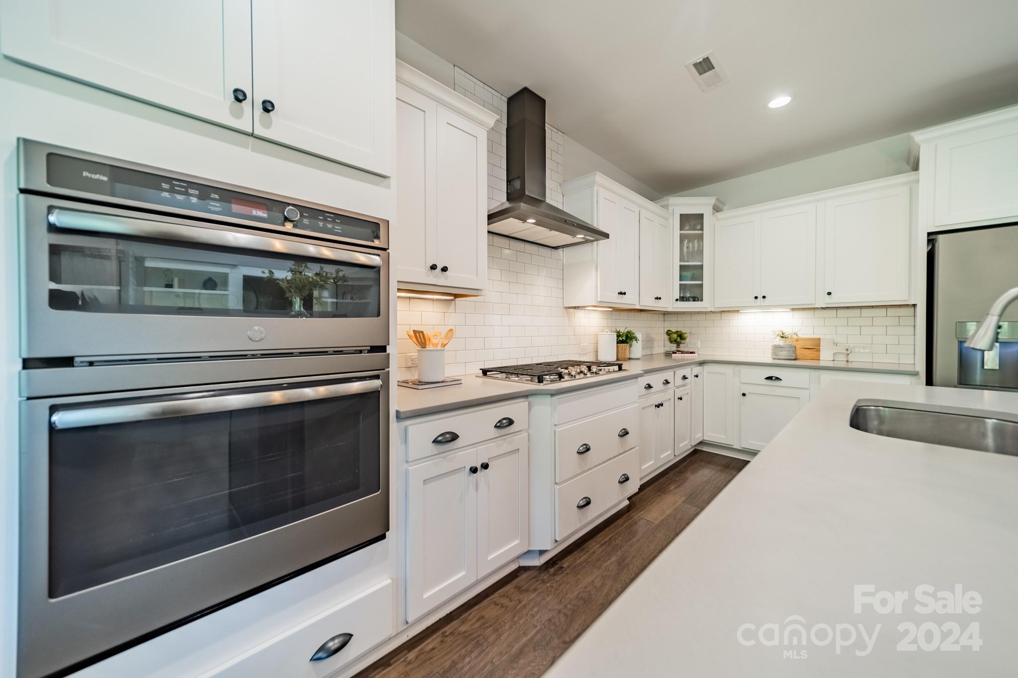2826 Walker Road Matthews, NC 28105 - Photo 23 of 45 a kitchen with stainless steel appliances white cabinets and a stove top oven