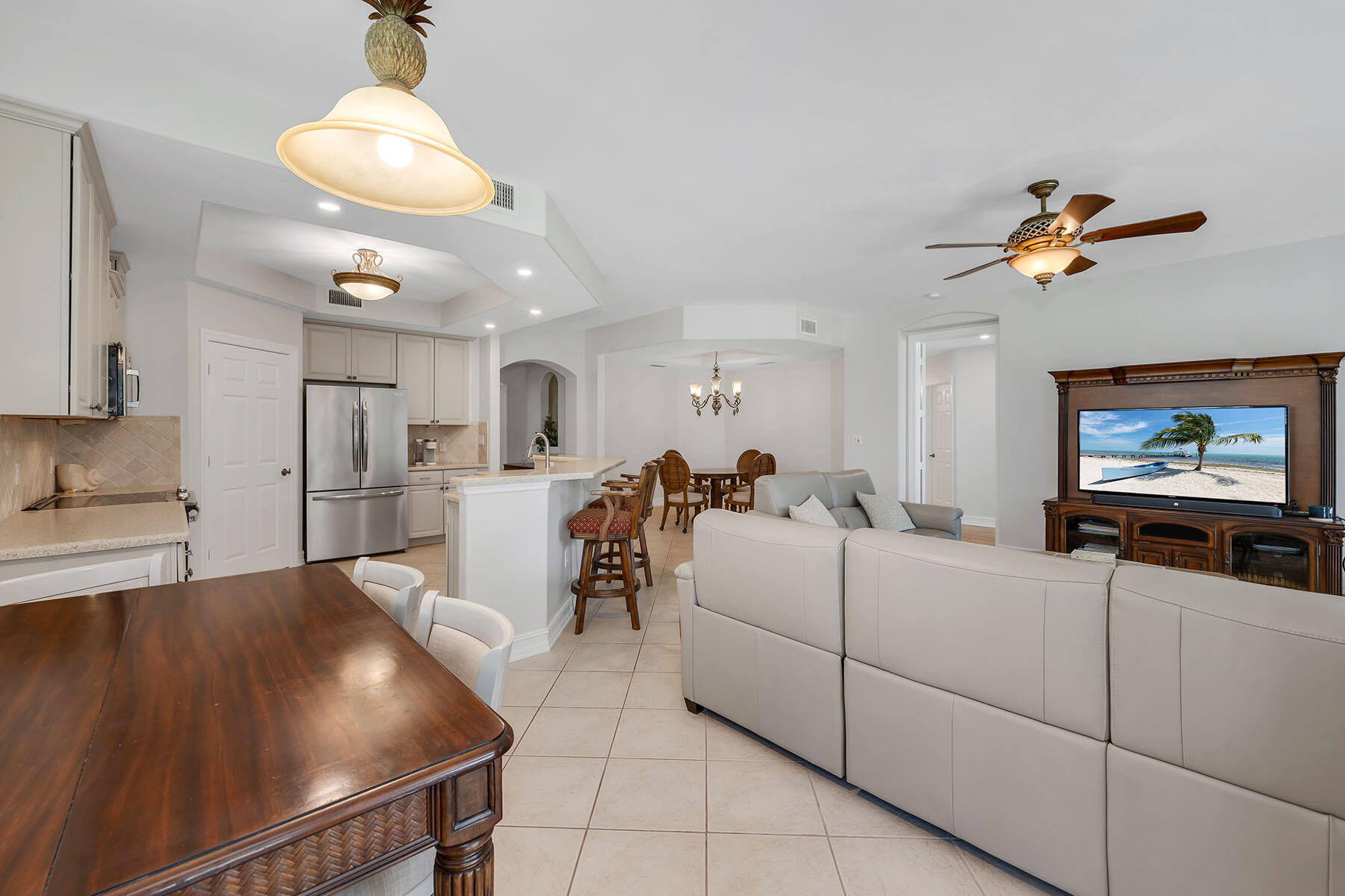1285 Rialto Way, Unit 102 Naples, FL 34114 - Photo 16 of 49 a living room with furniture and a flat screen tv