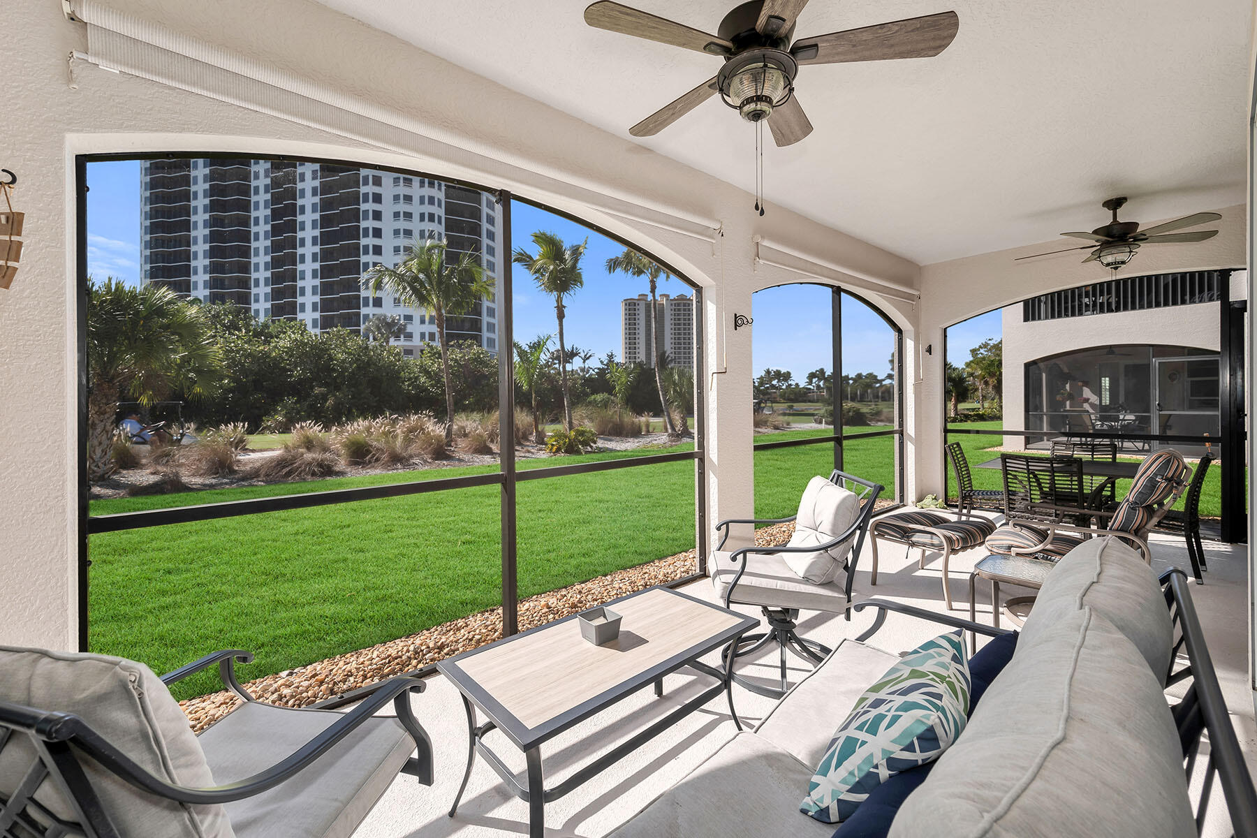 1285 Rialto Way, Unit 102 Naples, FL 34114 - Photo 27 of 49 a view of a patio with couches potted plants and a big yard