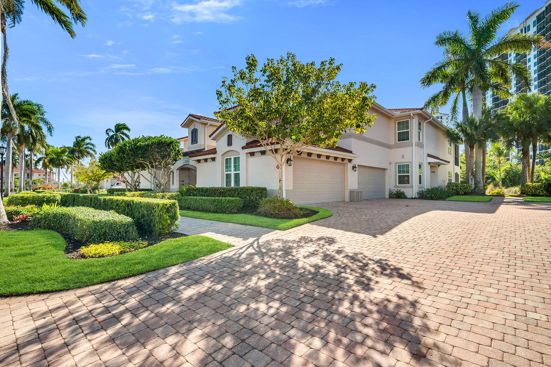 1285 Rialto Way, Unit 102 Naples, FL 34114 - Photo 40 of 49 a view of a white house with a yard and potted plants