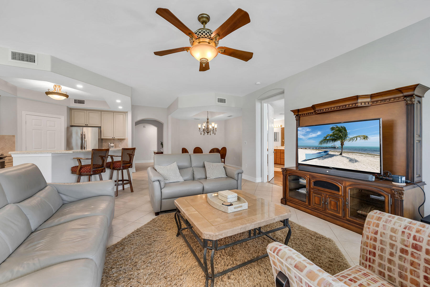 1285 Rialto Way, Unit 102 Naples, FL 34114 - Photo 6 of 49 a living room with furniture and a flat screen tv