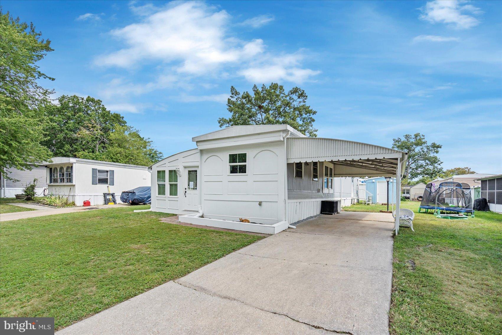 a front view of a house with a garden and trees