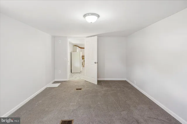 a view of an empty room with cabinet and closet