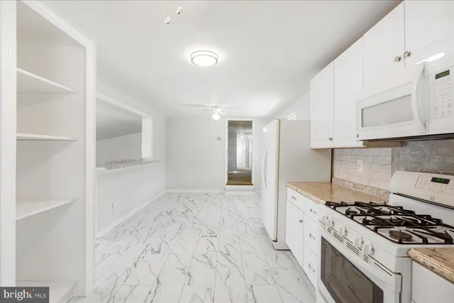 a kitchen with granite countertop a stove and a refrigerator