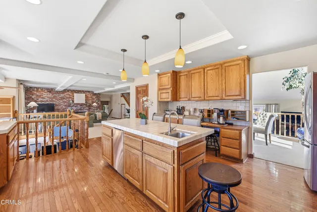 a kitchen with stainless steel appliances granite countertop a sink a stove and a wooden floors