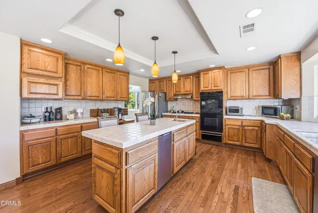 a large kitchen with stainless steel appliances granite countertop a stove sink and cabinets