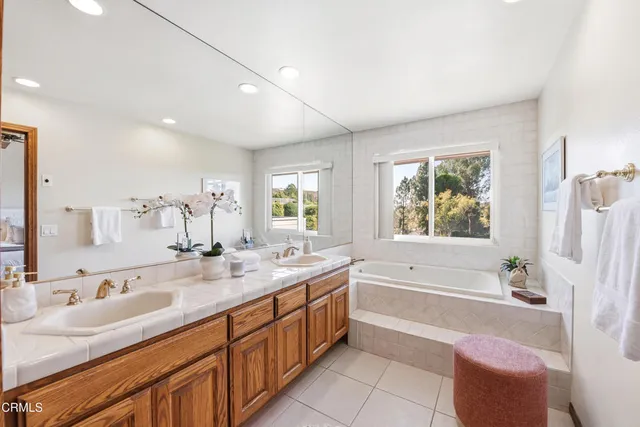 a spacious bathroom with a granite countertop tub sink and mirror