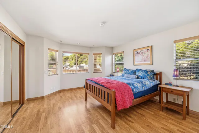 a spacious bedroom with a bed and wooden floor