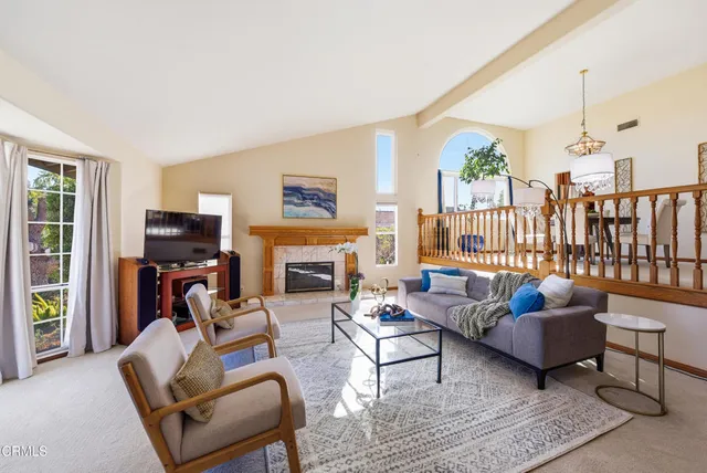 a living room with furniture a flat screen tv and a fireplace