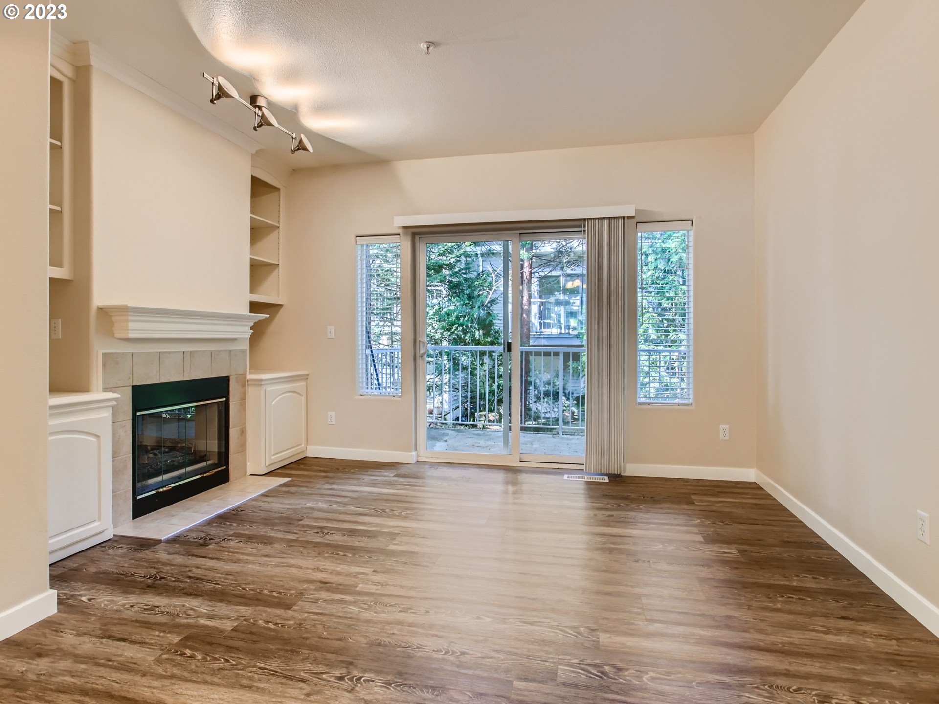 14140 Southwest Barrows Road, Unit 2 Portland, OR 97223 - Photo 6 of 30 a view of empty room with wooden floor and fireplace