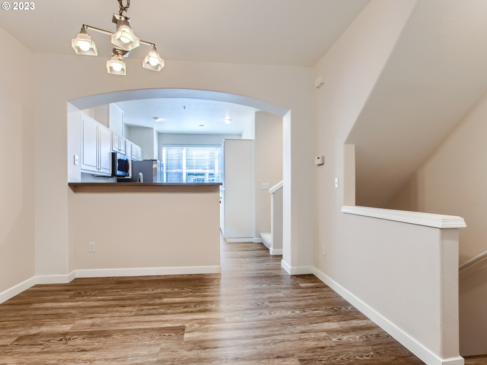 14140 Southwest Barrows Road, Unit 2 Portland, OR 97223 - Photo 9 of 30 a view of a room with wooden floor and chandelier