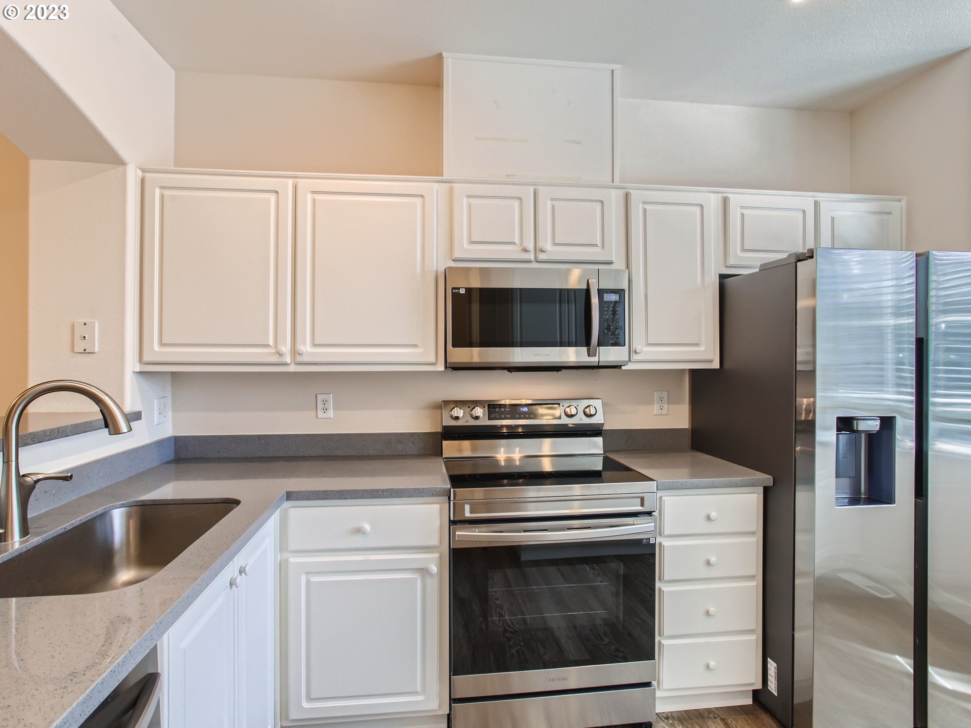 14140 Southwest Barrows Road, Unit 2 Portland, OR 97223 - Photo 10 of 30 a kitchen with white cabinets stainless steel appliances and a sink