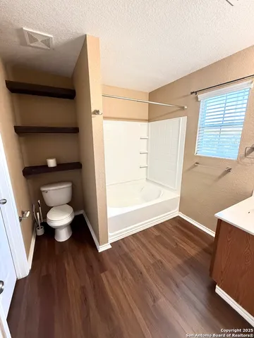 a bathroom with a toilet and a tub