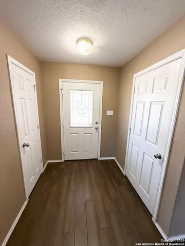 an empty room with wooden floor and window