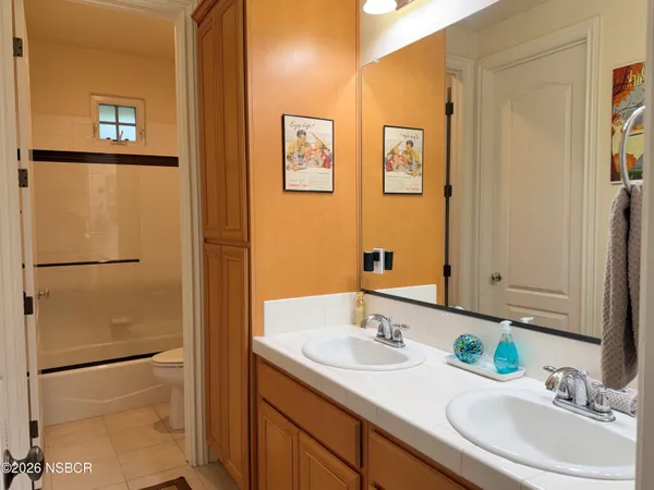 a en suite bathroom with a granite countertop sink and a mirror