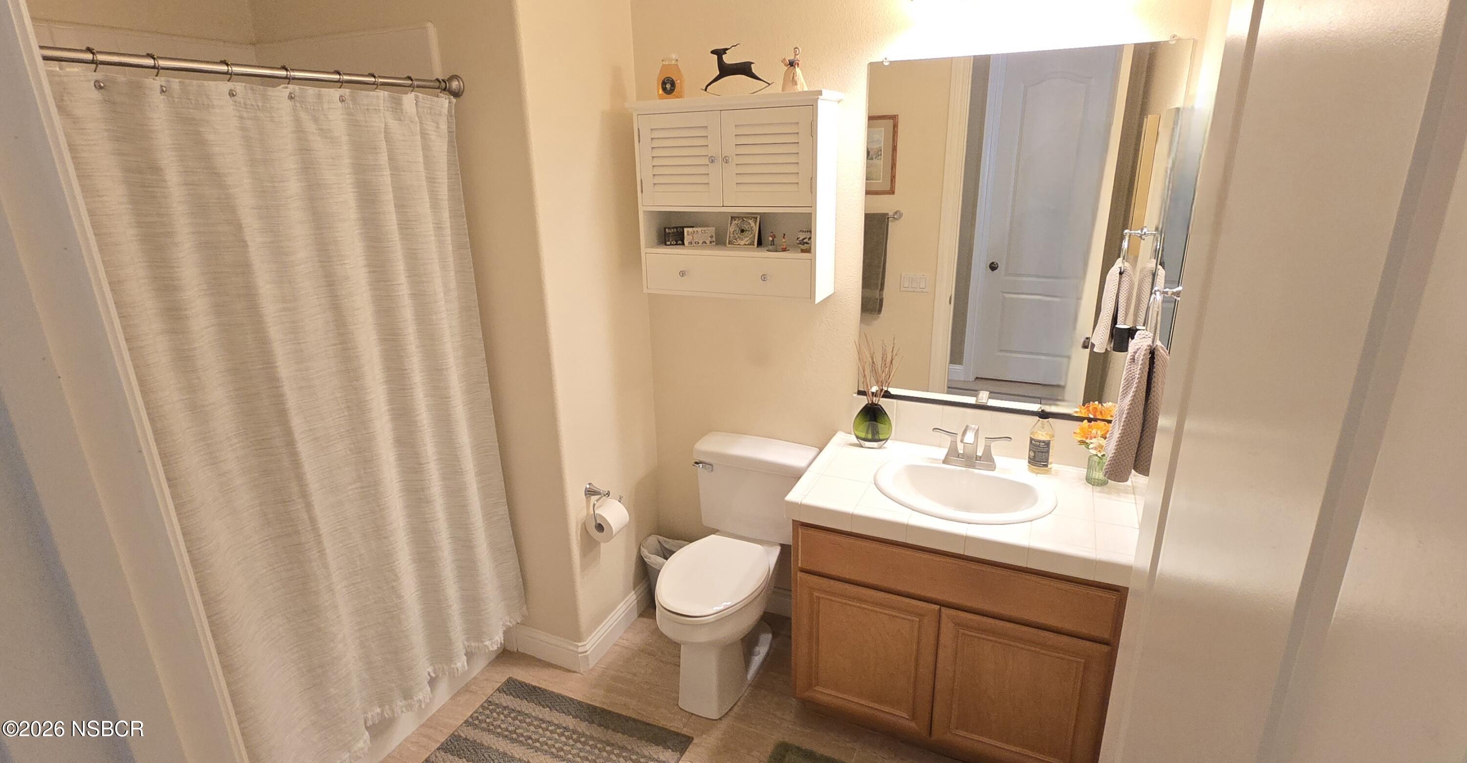 757 Onstott Road Lompoc, CA 93436 - Photo 25 of 39 a bathroom with a sink a toilet and shower curtain
