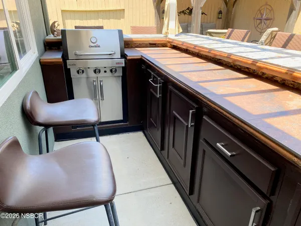 a view of a patio with a dining table and chairs under an umbrella